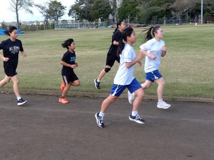 陸上競技練習会に参加した生徒5名がランニングをしています。