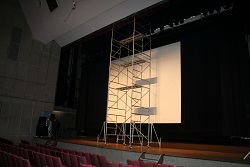 市民会館のステージに置かれた、高所で作業ができるよう金属製の階段と足場がセットになった「ローリングタワー」。