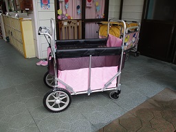 保育所で利用するピンク色の散歩車の写真