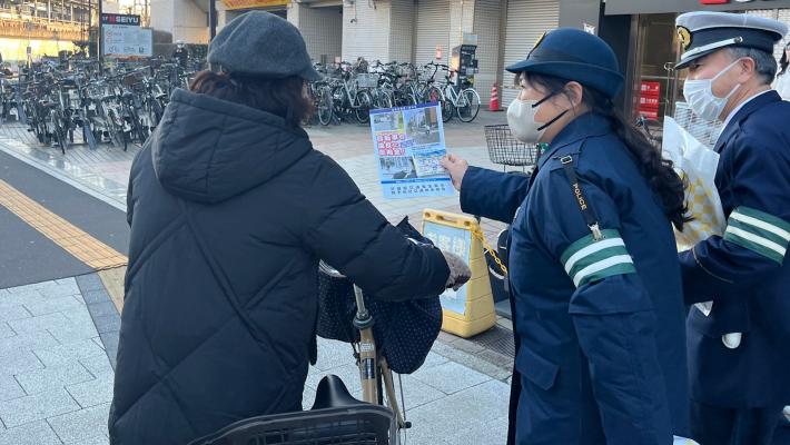 取手駅西口で警察官が自転車利用者に本制度を説明する様子