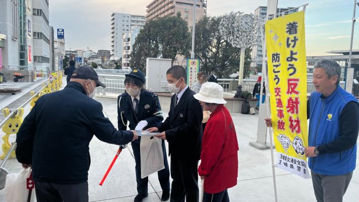 警察官、高校生、母の会のかたが交通安全を呼びかける様子