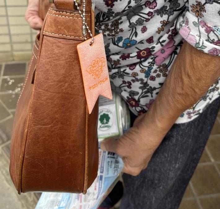 配布した反射ストラップを市民のかたが鞄に着けている様子
