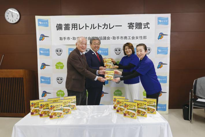 取手市商工会女性部より備蓄用レトルトカレーを寄贈している様子
