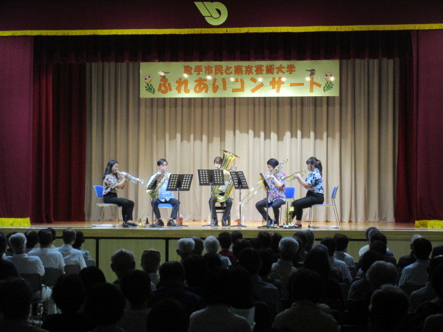 「ふれあいコンサート」看板のある舞台上で金管五重奏を披露中。