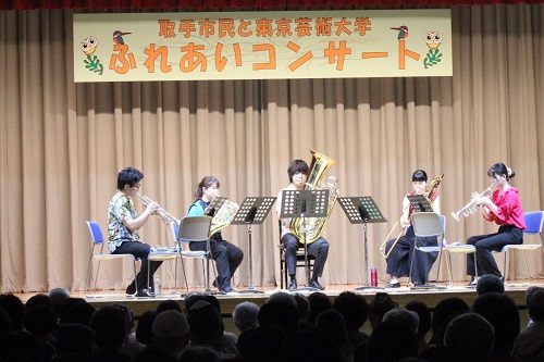 芸大生の男性2人、女性3人がステージ上で金管5重奏を演奏している様子