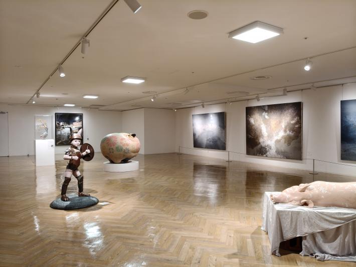 壁に大きな絵が飾られ、床に4点の工芸作品が飾られている