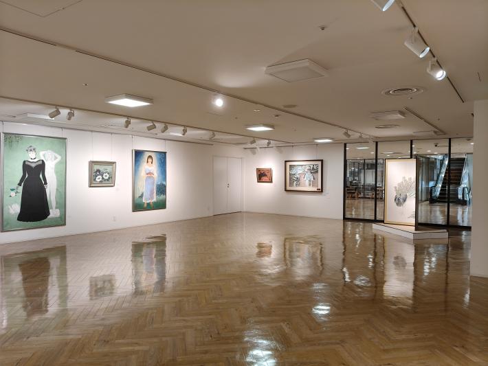 壁に大きな絵と小さい絵が飾られ、床に1点屏風が飾られている