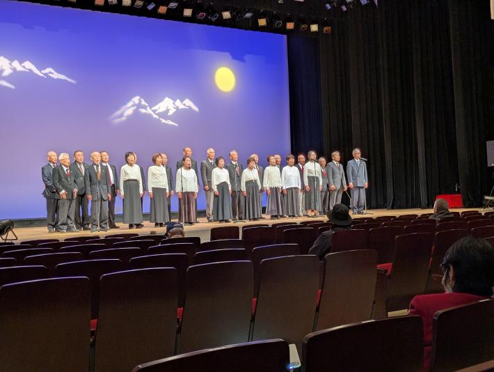 市民会館の舞台で20数人の男女が背筋を伸ばしたきれいな姿勢で詩を吟じています