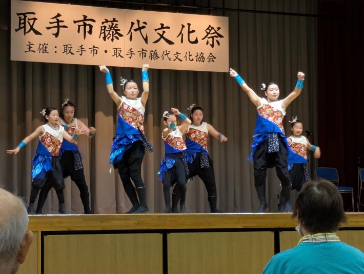 7人の女性が和風モダンな衣装を身にまとい、息があったパフォーマンス披露しています