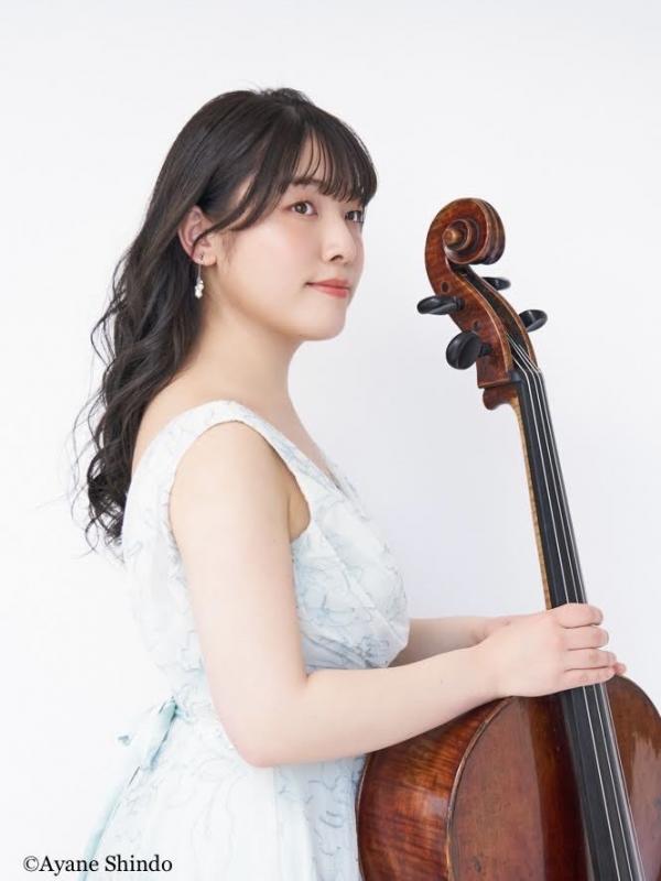 白いドレスを着た女性がチェロをささえている
