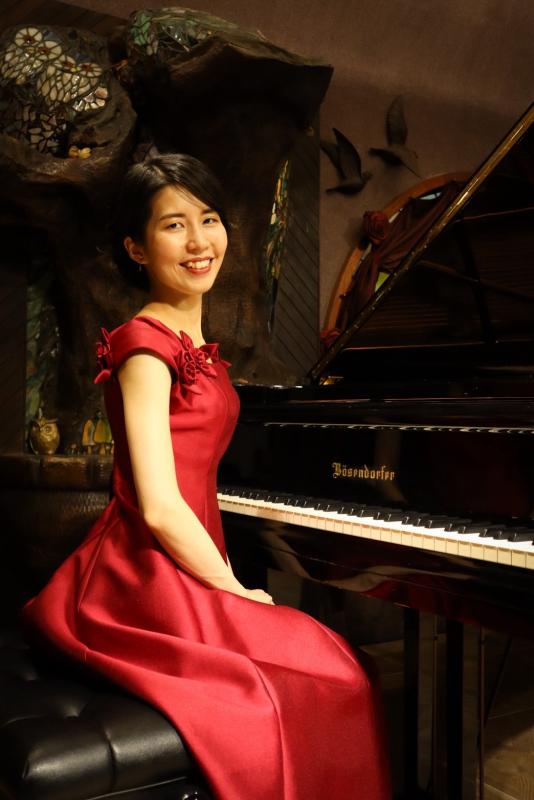 ピアノの前に座る黒住友香さんの写真です。