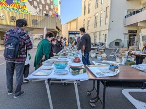 陶芸のチャリティ販売会で、いろいろな作品の中からお客さんが品定めをしている様子