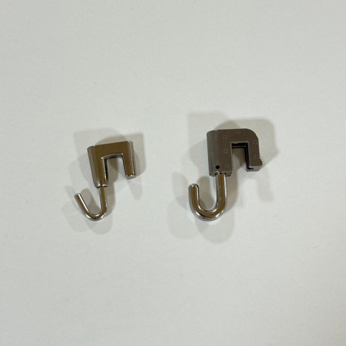 展示用のワイヤーをかけるため、壁の上部に取り付けるフック。サイズの違う2種類が並んでいる。