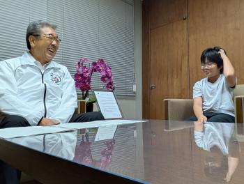 大人と小学生が応接室で歓談している様子