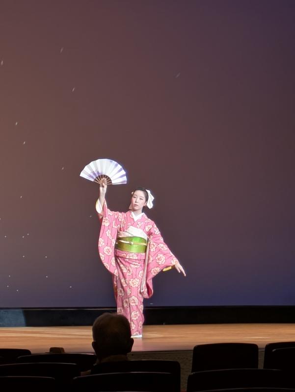 若い和装の女性が扇子を手に舞踊を披露している