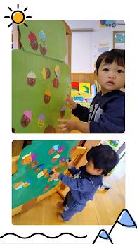 男の子2人がどんぐりのイラストを貼っている写真