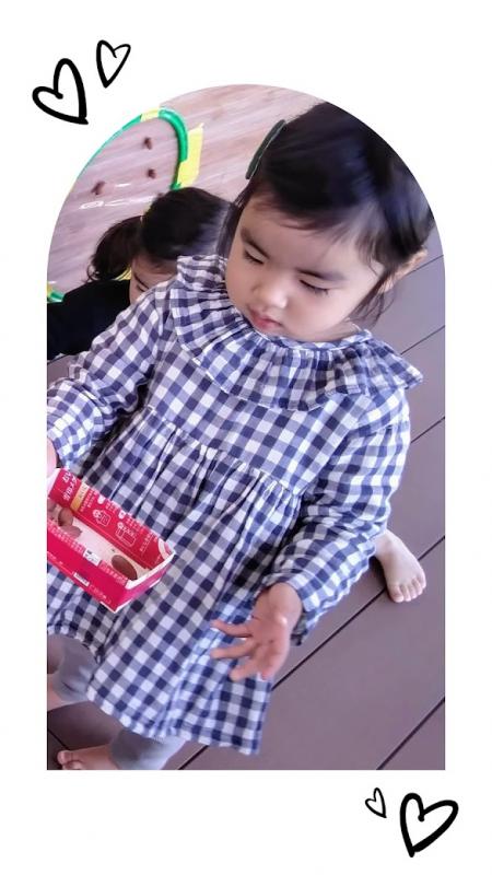 女の子が箱の中のどんぐりを見せている写真