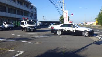 パトカーが警察署の敷地から国道に出ようとしている写真