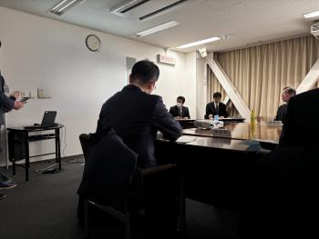 会議室で資料を見る男性たち