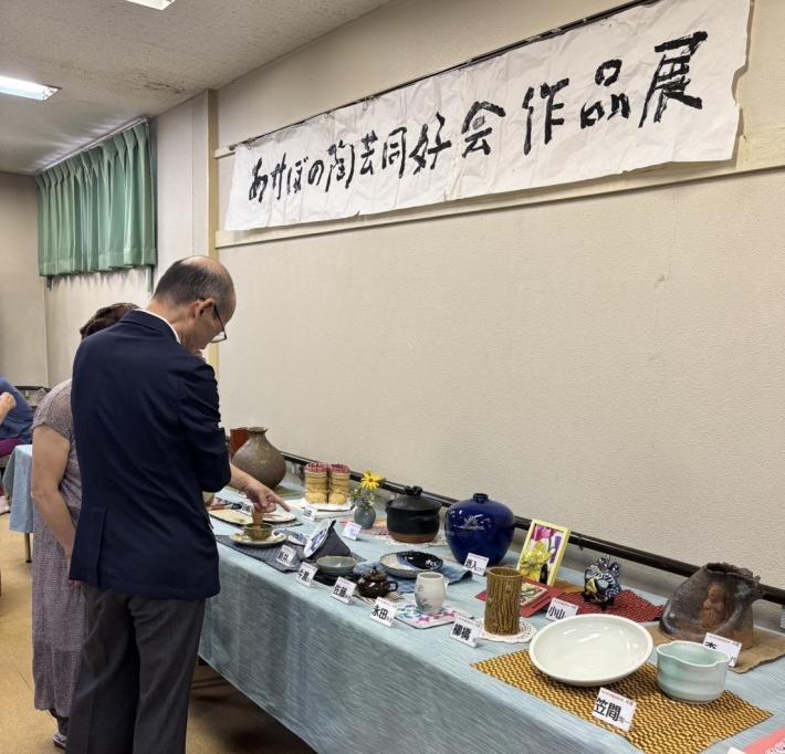 陶器の作品展示を鑑賞する男性
