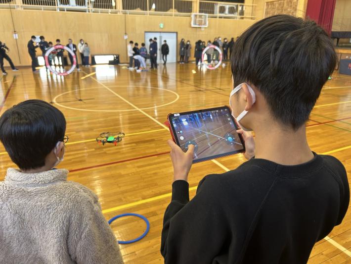 リモコンで直接ドローンを動かすこどもたち