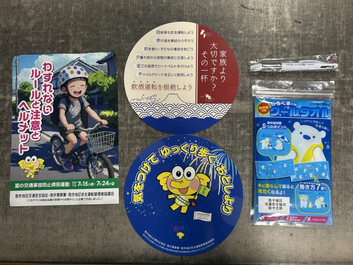 うちわ、クールタオル、ボールペン、チラシが置かれている