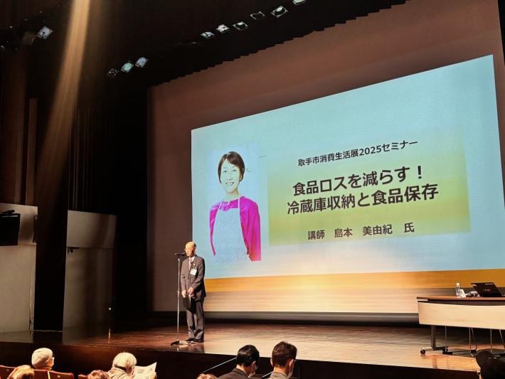 ステージの上であいさつをする男性