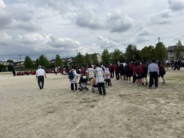 校庭に集まる園児と学生たち