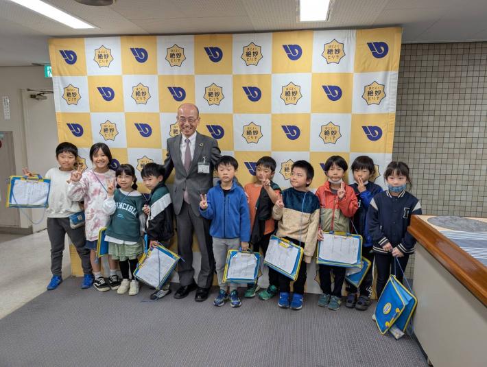 パネルの前に立つ小学生と男性