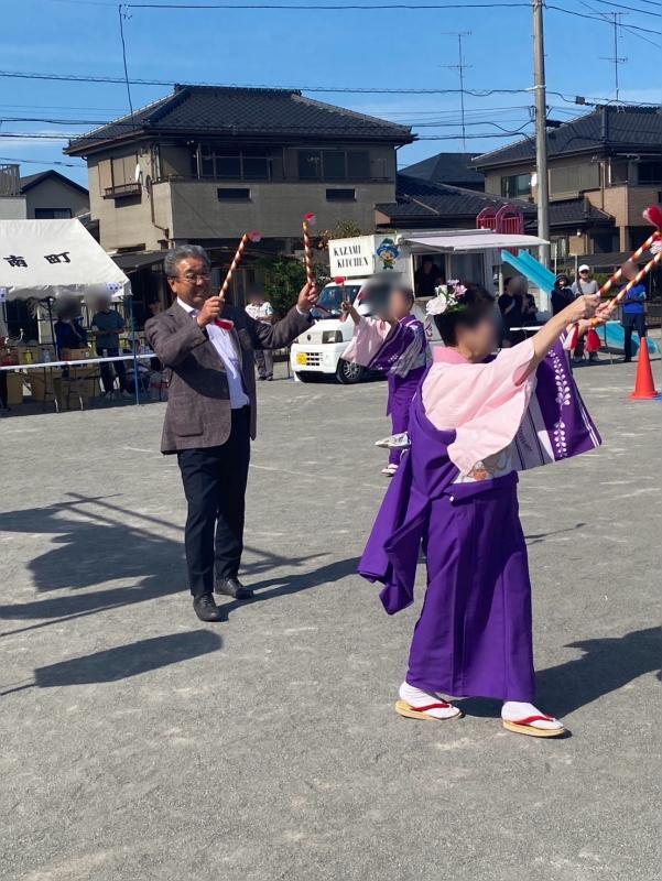棒を両手に持って踊る男女