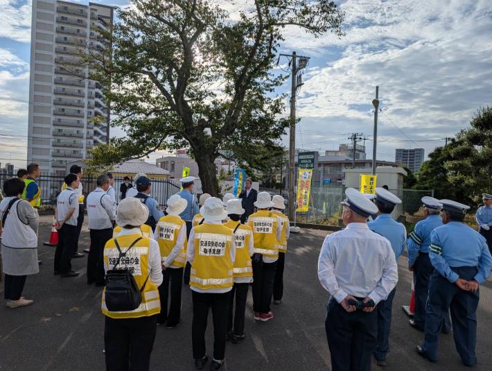 駅前に集まった参加者に話をする男性