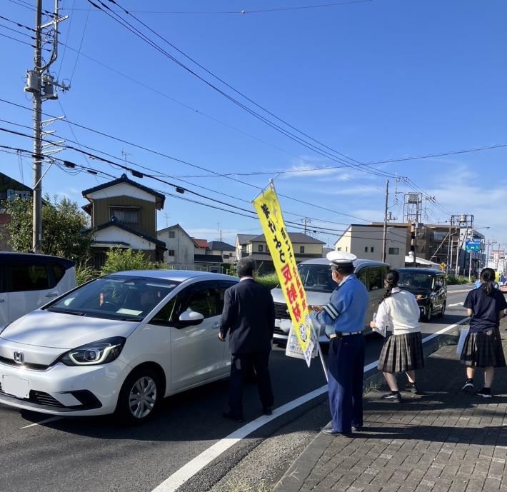 車の利用者に啓発グッズを配る男性