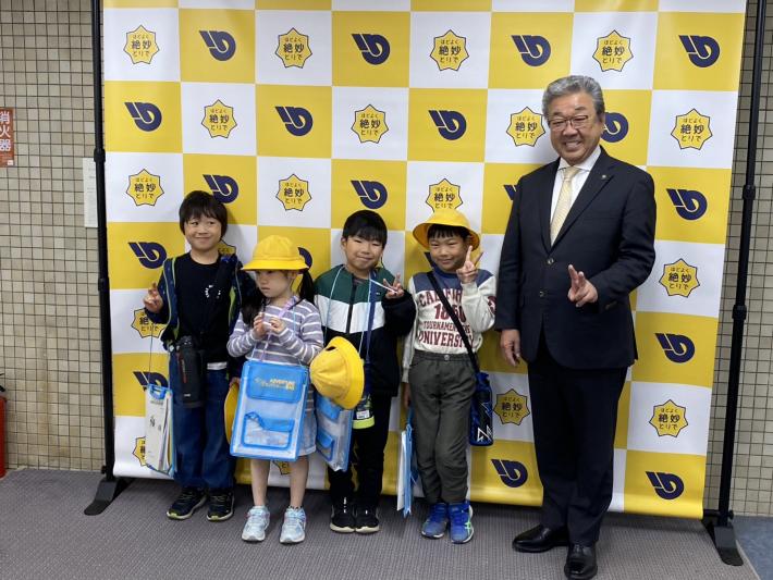 パネルの前に立つ小学生と男性