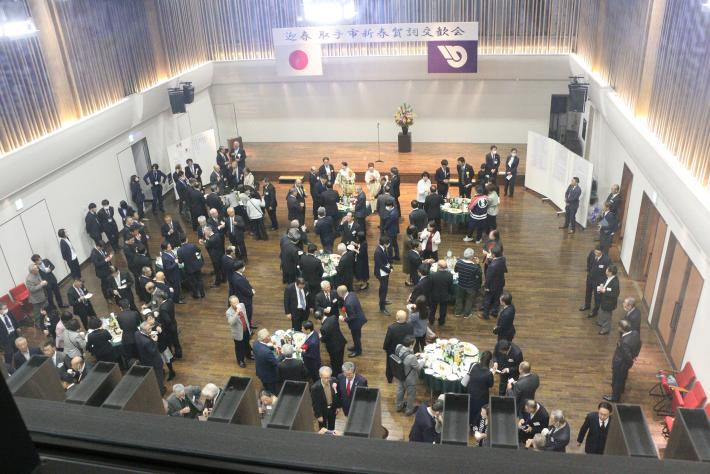 宴会場を上から見上げた様子。テーブルの周りに人が集まっている。