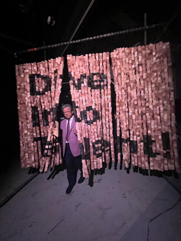 光るすだれをくぐる男性