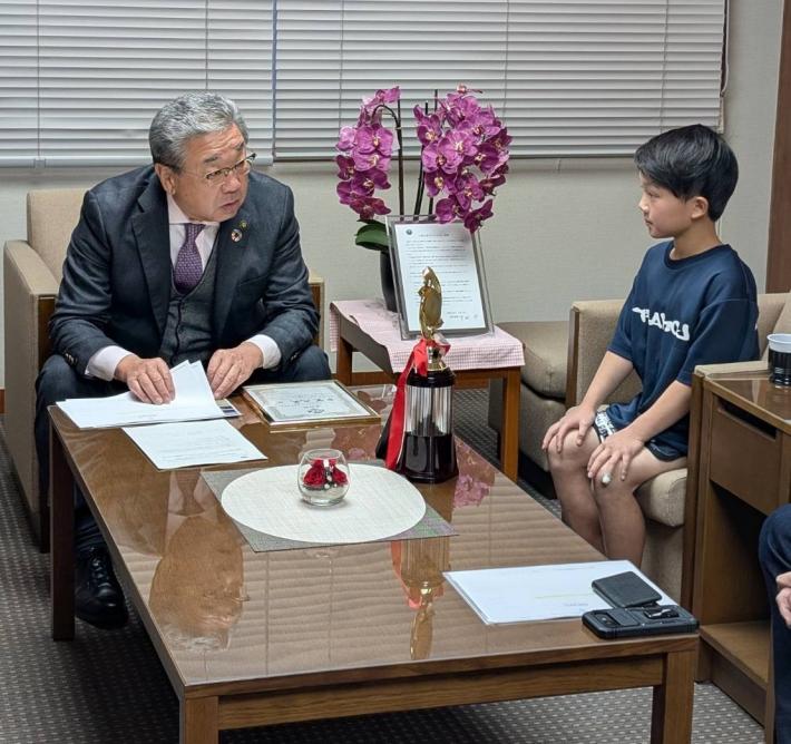 座って話をする男の子と大人男性