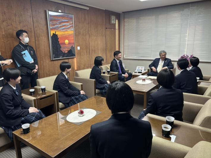 席に座る男性2名と女子生徒7名が話をしている