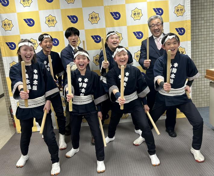 パネルの前でポーズをとる法被を着たこどもたち