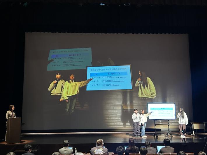 スクリーンとモニターにこどもたちと発表資料が映っている