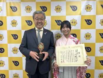 袴を着た中学生とスーツを着た男性が並んで立っている