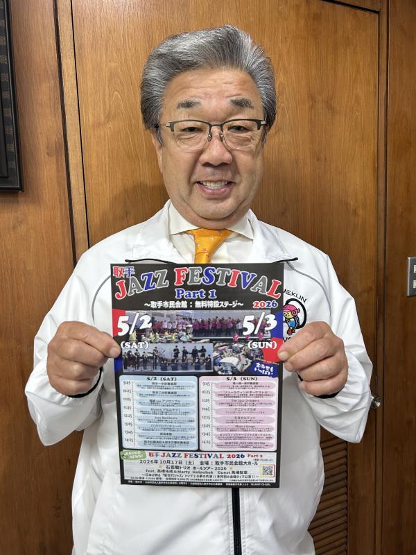 チラシを持つ白いジャンパーを着た男性