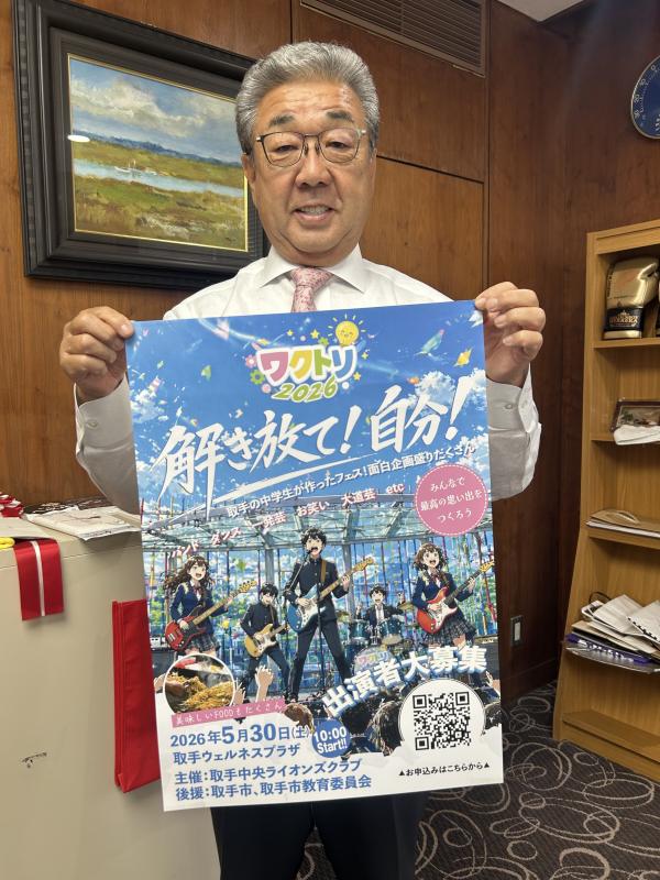 ポスターの端を持って立つ男性