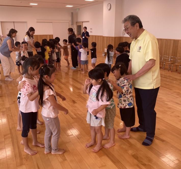 子どもたちに囲まれて話をする男性