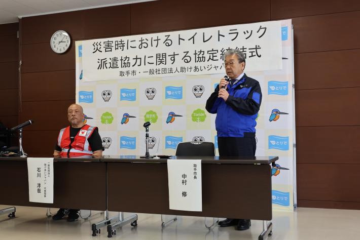 協定の締結式に参加する2人の男性