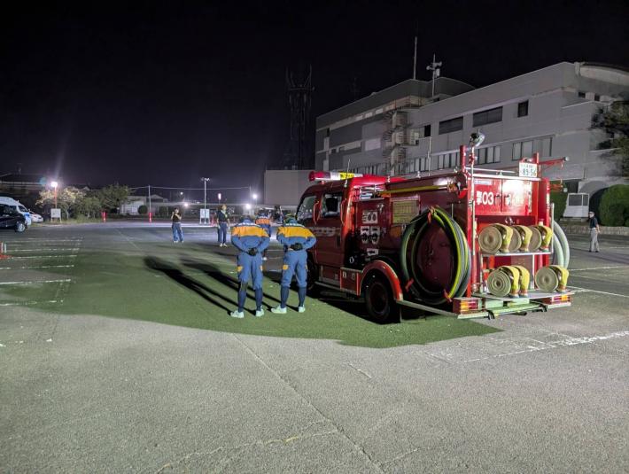 消防車の前に立つ消防団