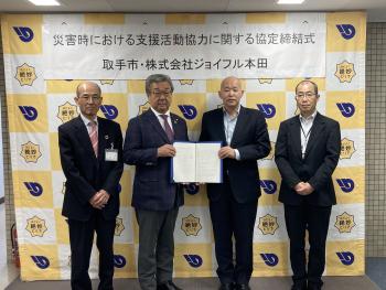 締結式において集合写真を撮影する4人の男性