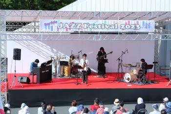 屋外ステージの上で演奏するDropout Jazz Ensembleメンバー5人の写真