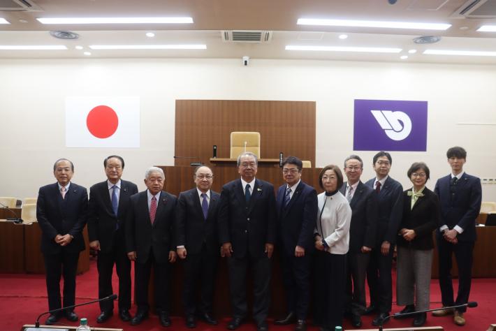 男性と女性の議員数名が議場で並んで立っている