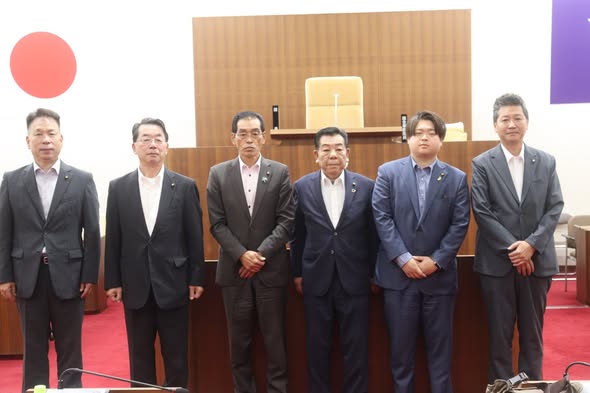 議場で、男性の議員数名が横になって並んでいる