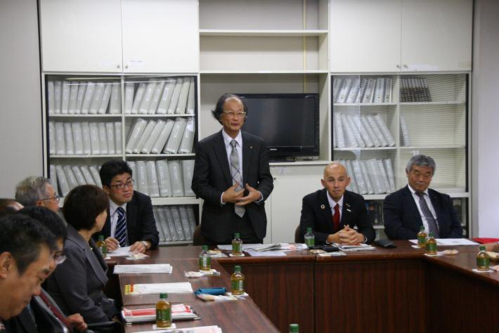 ロの字型に並べられた机に座る議員。野崎委員長の隣に座る男性の伊勢市議(楠木副委員長)がその場で起立し、挨拶をしている。